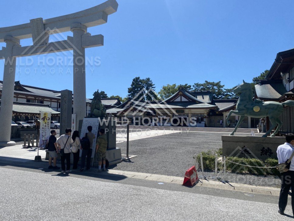 Stone torii gate and shrine courtyard in bright sunlight. Hiroshima, Japan.