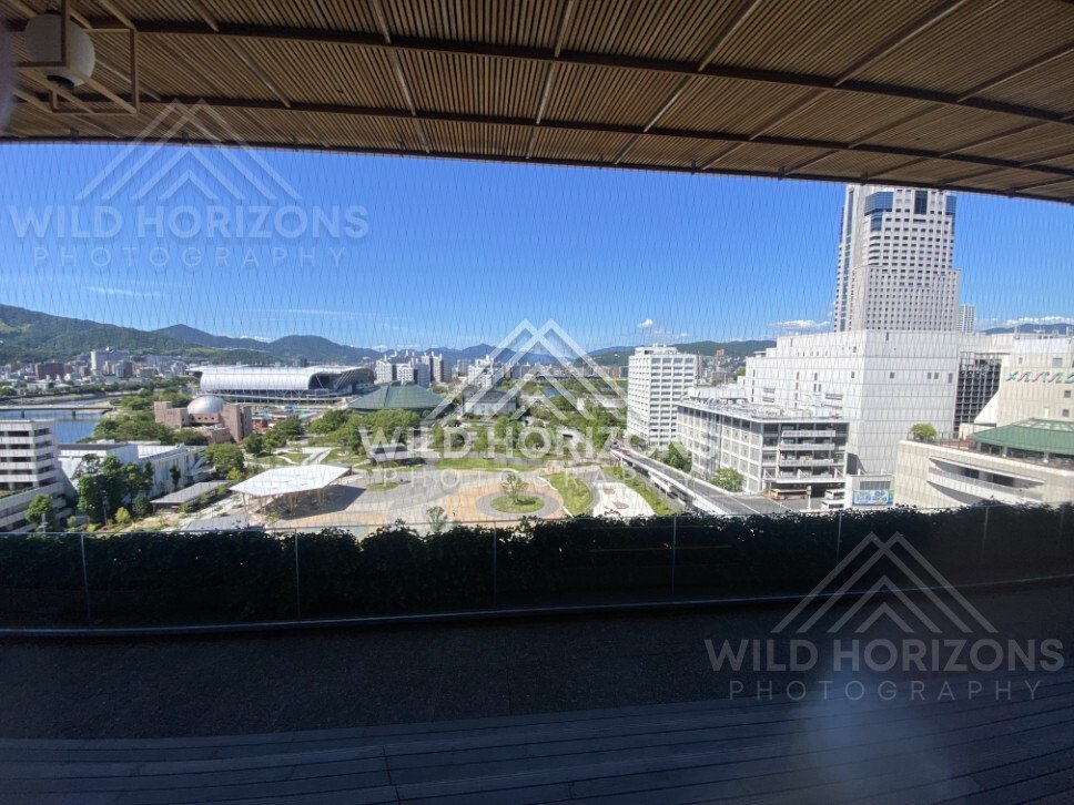 Elevated city view over a green park and modern buildings. Hiroshima, Japan.