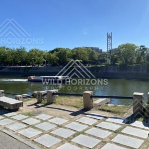 Riverside promenade with a boat passing along the waterway in Hiroshima. Hiroshima, Japan.