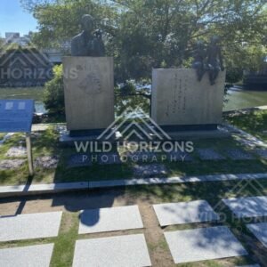 Bronze statues and engraved stone blocks beside a riverside path. Hiroshima Peace Memorial Park, Hiroshima, Japan.