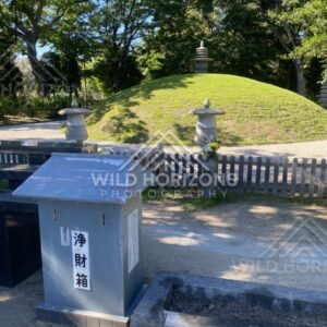 Small grassy memorial mound with a stone lantern and offering box. Hiroshima Peace Memorial Park, Hiroshima, Japan.
