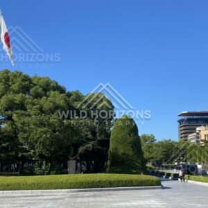 Japanese flag flying above manicured gardens in Hiroshima Peace Memorial Park. Hiroshima Peace Memorial Park, Hiroshima, Japan.