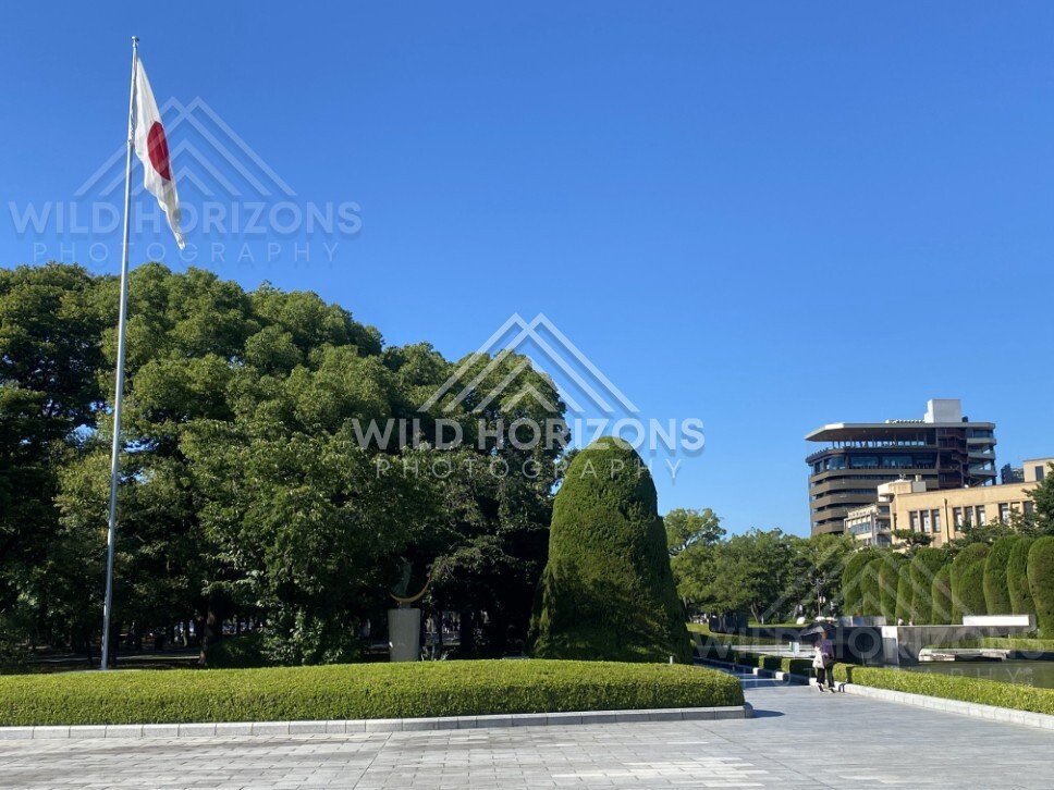 Japanese flag flying above manicured gardens in Hiroshima Peace Memorial Park. Hiroshima Peace Memorial Park, Hiroshima, Japan.