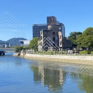 Atomic Bomb Dome reflected in calm river waters under bright sunlight. Hiroshima Peace Memorial, Hiroshima, Japan.