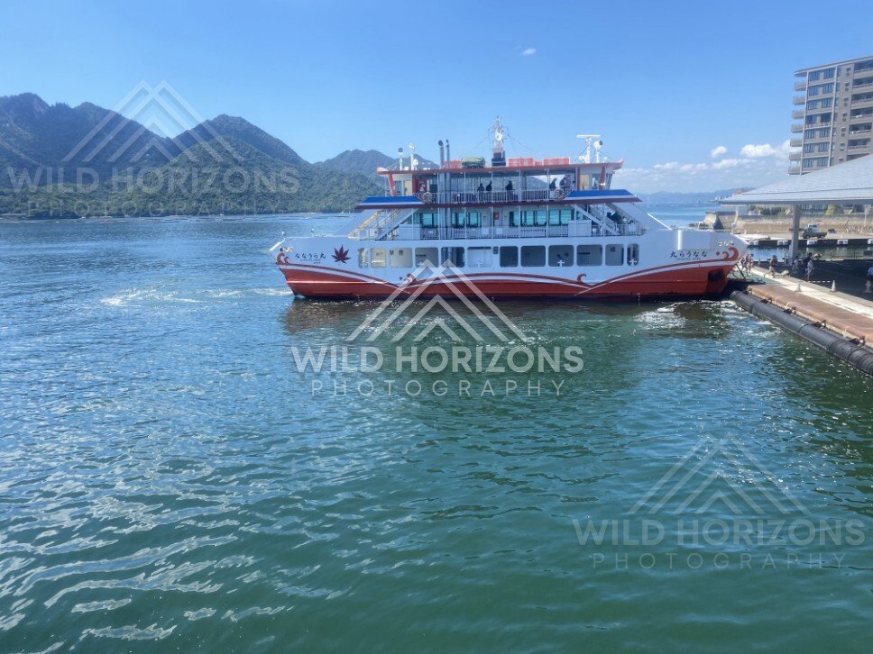 Passenger ferry docked at the waterfront on Miyajima Island. Miyajima, Hiroshima, Japan.