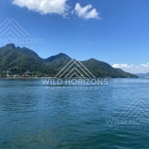 Expansive bay view with layered mountain ranges under clear skies. Miyajima, Hiroshima, Japan.