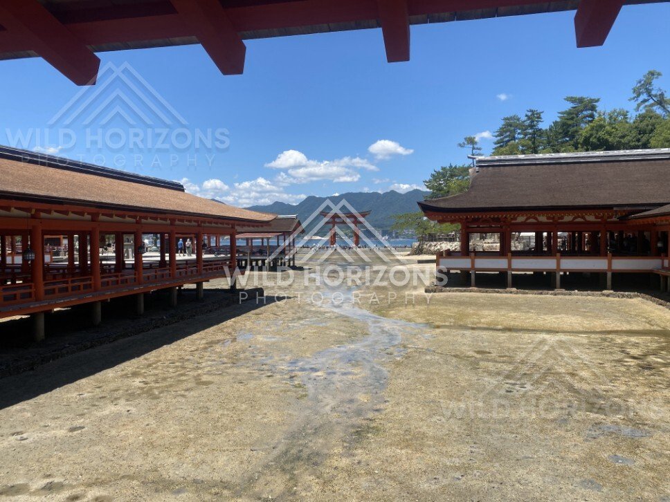 Symmetrical view between shrine corridors with the torii gate beyond. Miyajima, Hiroshima, Japan.