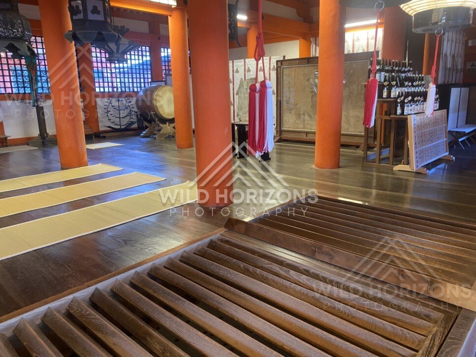 Interior view of a shrine hall with drums and ritual objects. Miyajima, Hiroshima, Japan.