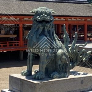 Guardian komainu statue on a stone plinth within the shrine complex. Miyajima, Hiroshima, Japan.