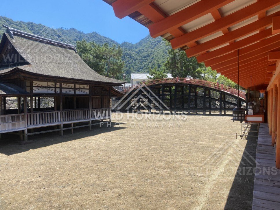 Traditional wooden buildings and arched bridge within the shrine grounds. Miyajima, Hiroshima, Japan.
