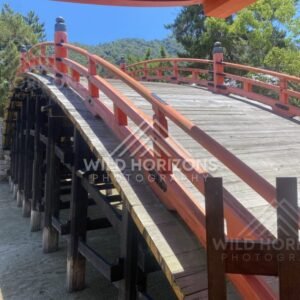 Red arched bridge rising above the shrine courtyard. Miyajima, Hiroshima, Japan.