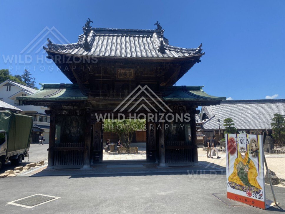 Traditional temple gate marking the entrance to a historic precinct. Miyajima, Hiroshima, Japan.