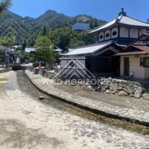 Stone-lined stream running through a traditional residential street. Miyajima, Hiroshima, Japan.