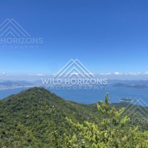 Panoramic view across forested hills and coastline from elevated viewpoint. Miyajima, Hiroshima, Japan.