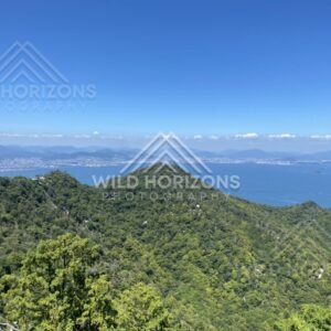 Panoramic view across forested ridges toward distant coastline. Miyajima, Hiroshima, Japan.