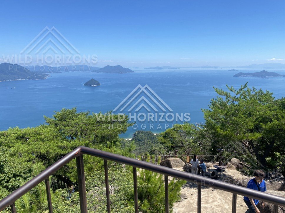 Lookout viewpoint overlooking blue bay and scattered islands. Miyajima, Hiroshima, Japan.