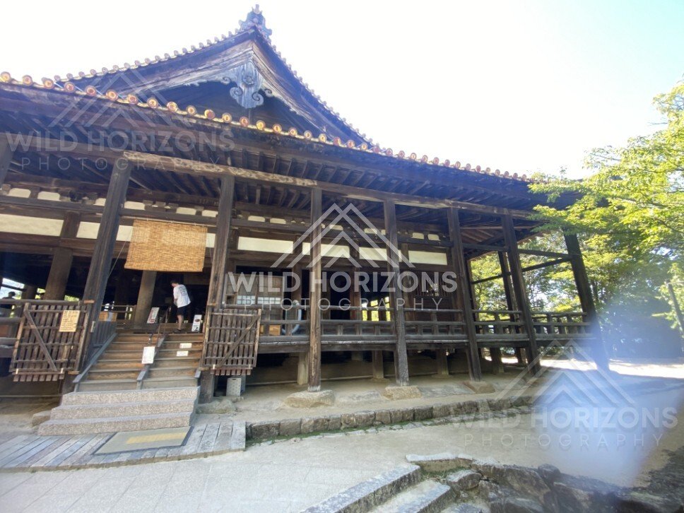 Side view of traditional temple hall with raised wooden platform. Miyajima, Hiroshima, Japan.