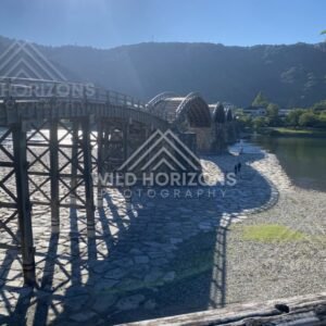 Wide view of the Kintaikyo Bridge stretching across the river at low water. Iwakuni, Yamaguchi, Japan.