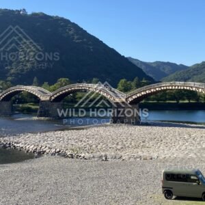 Kintaikyo Bridge framed by mountains with visitors below. Iwakuni, Yamaguchi, Japan.