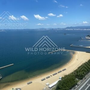High viewpoint overlooking sandy beach and blue coastal water. Fukuoka, Japan.