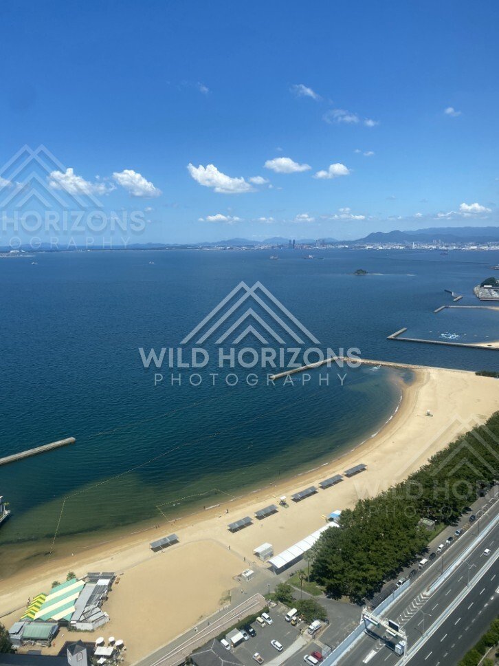 High viewpoint overlooking sandy beach and blue coastal water. Fukuoka, Japan.