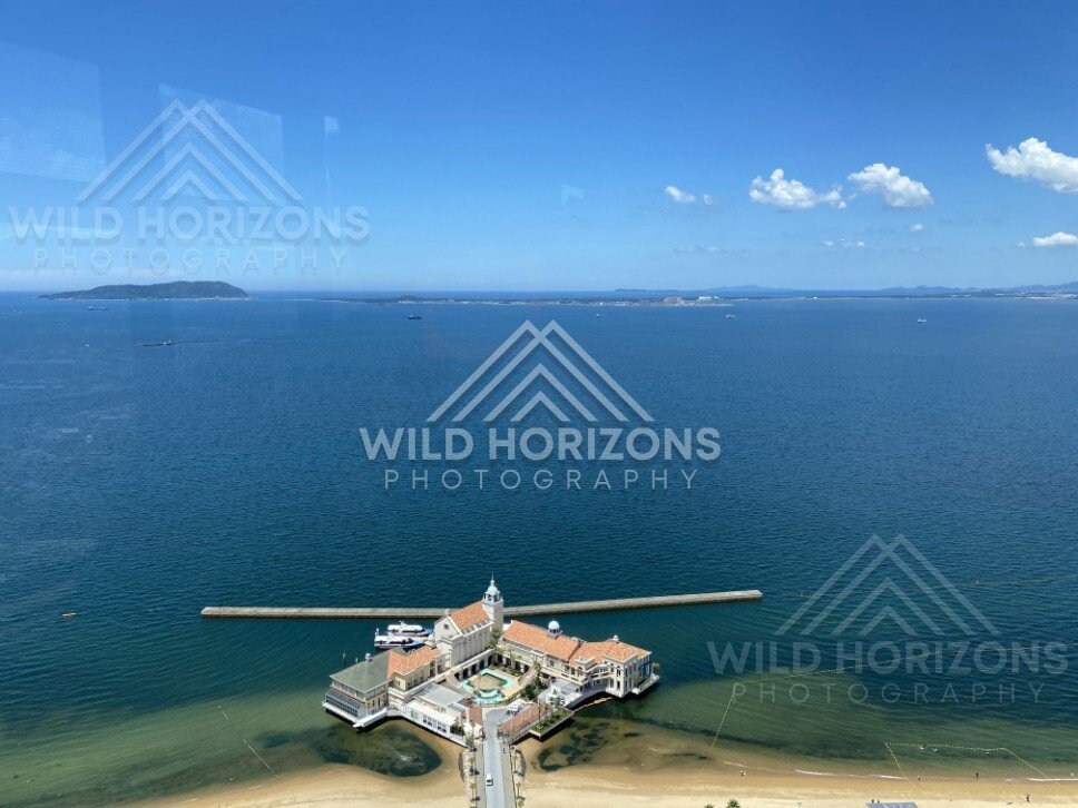 Wide ocean view with small island on the horizon under clear sky. Fukuoka, Japan.