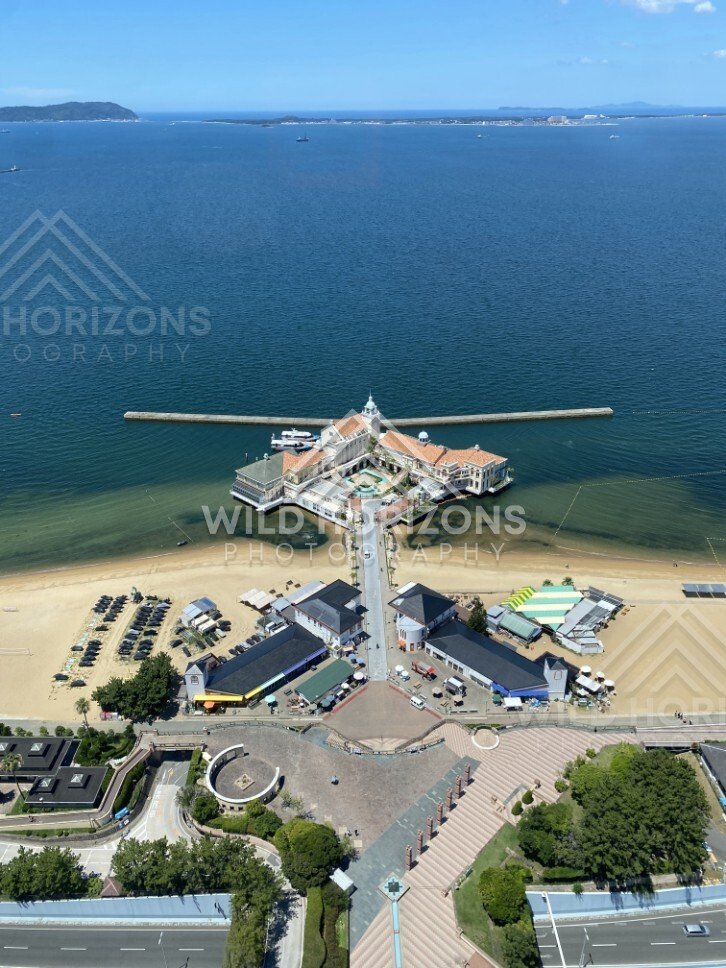 Top-down view of seaside building extending into the water. Fukuoka, Japan.