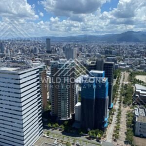 City skyline viewed from high elevation beneath textured clouds. Fukuoka, Japan.