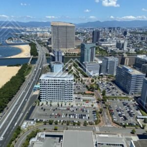 Urban coastline where highway, buildings, and beach meet the sea. Fukuoka, Japan.