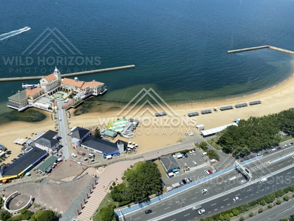 High-angle view of pier building, beach, and coastal road. Fukuoka, Japan.