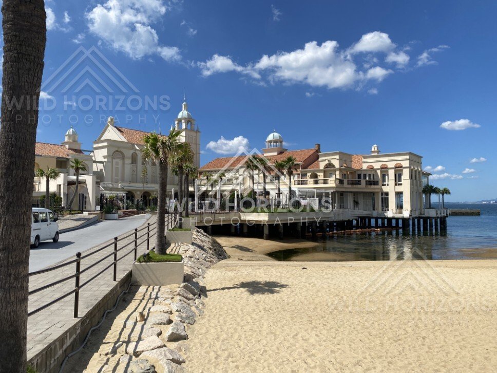 Beachfront building on stilts beside calm bay and sandy shore. Fukuoka, Japan.