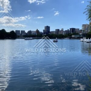 Calm lake waters in Ohori Park with city skyline beyond. Ohori Park, Fukuoka, Japan.