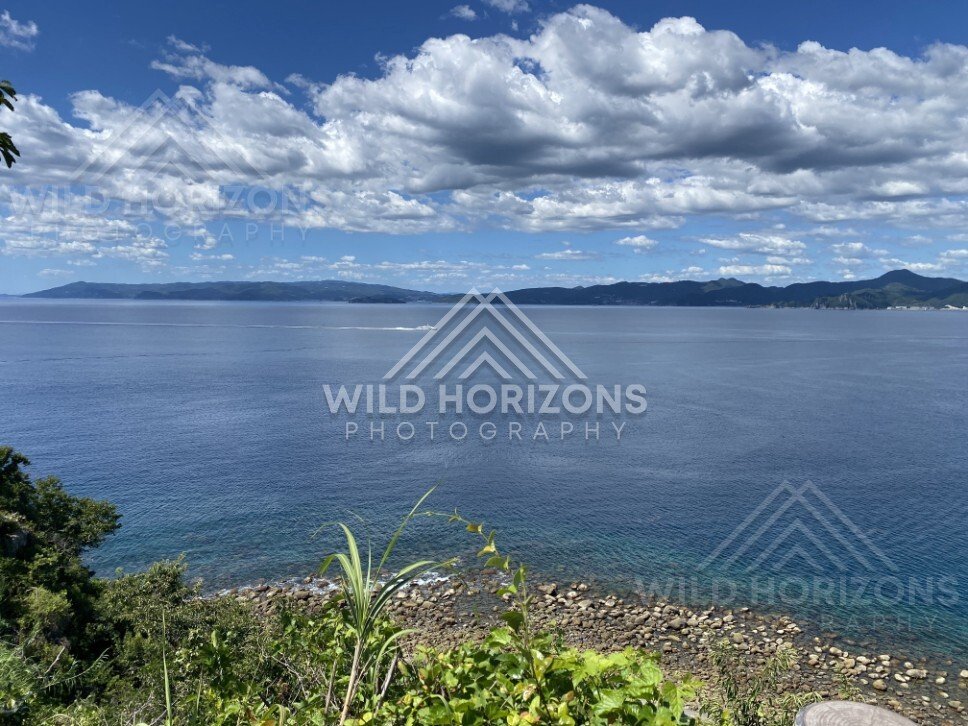 Rocky coast and open sea under dramatic cumulus clouds. Nagasaki, Japan.