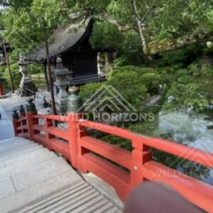 Red Bridge Railings Beside a Small Shrine Pavilion and Waterway. Fukuoka, Japan.