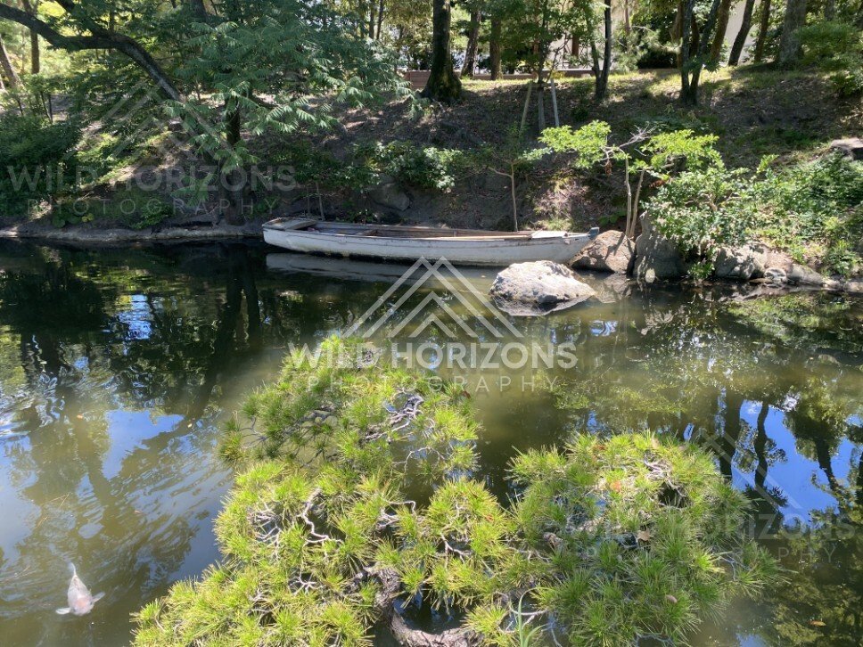 Boat Moored Along a Shaded Pond Bank. Hiroshima, Japan.