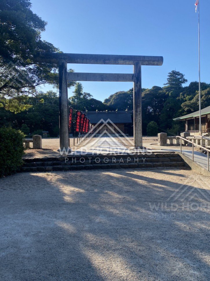 Stone Torii Gate and Shrine Approach with Red Banners. Matsue, Japan.