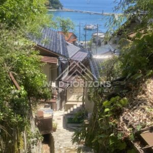 Rooftops and Harbor View Through Bamboo and Foliage. Mihonoseki, Japan.