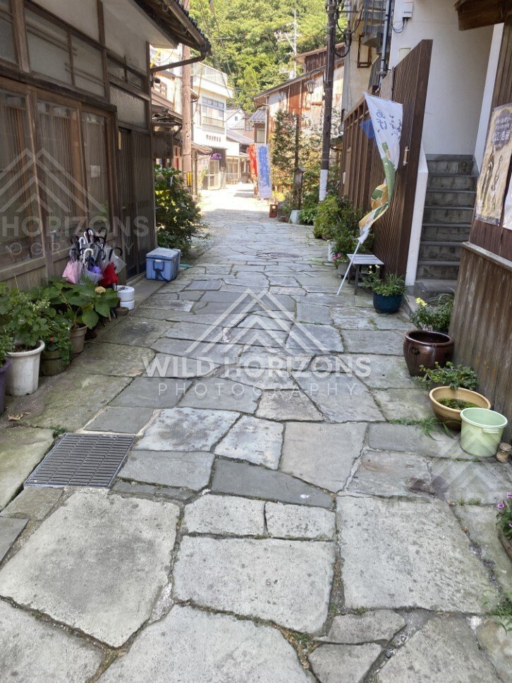 Stone Lane With Umbrellas, Banners, and Small Street Details. Mihonoseki, Japan.