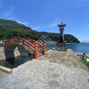 Arched Bridge With Red Railings Beside a Stone Lantern on the Pier. Mihonoseki, Japan.