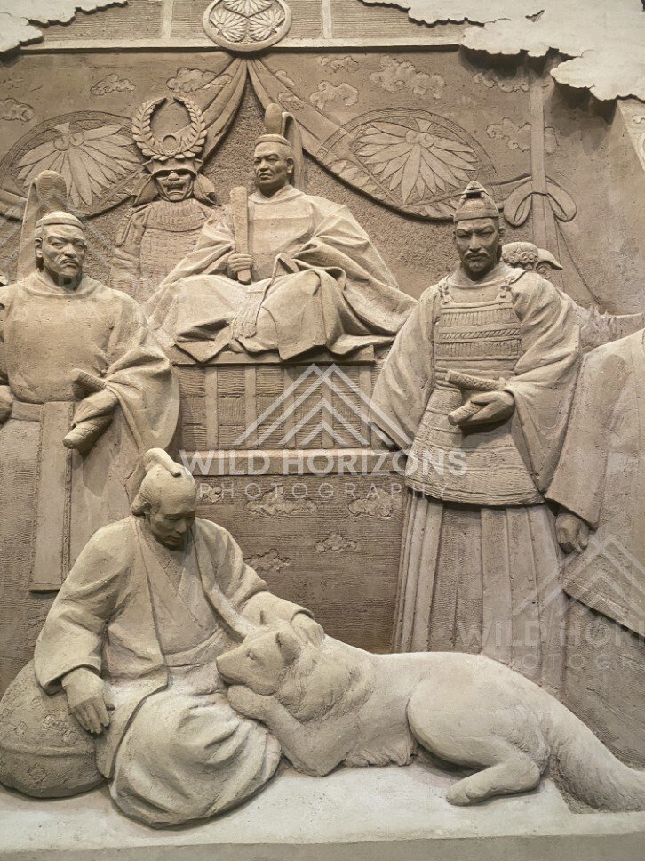 Sand Sculpture Panel of Seated Figures and Resting Dog. Tottori Sand Museum, Japan.