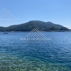 Panoramic view of Ine’s funaya boathouses along a clear blue bay. Ine, Japan