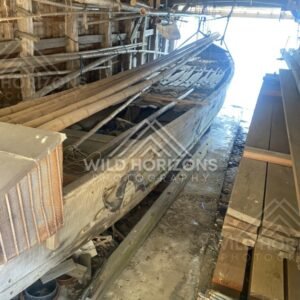 Traditional wooden fishing boat stored inside a covered seaside boathouse. Ine, Japan