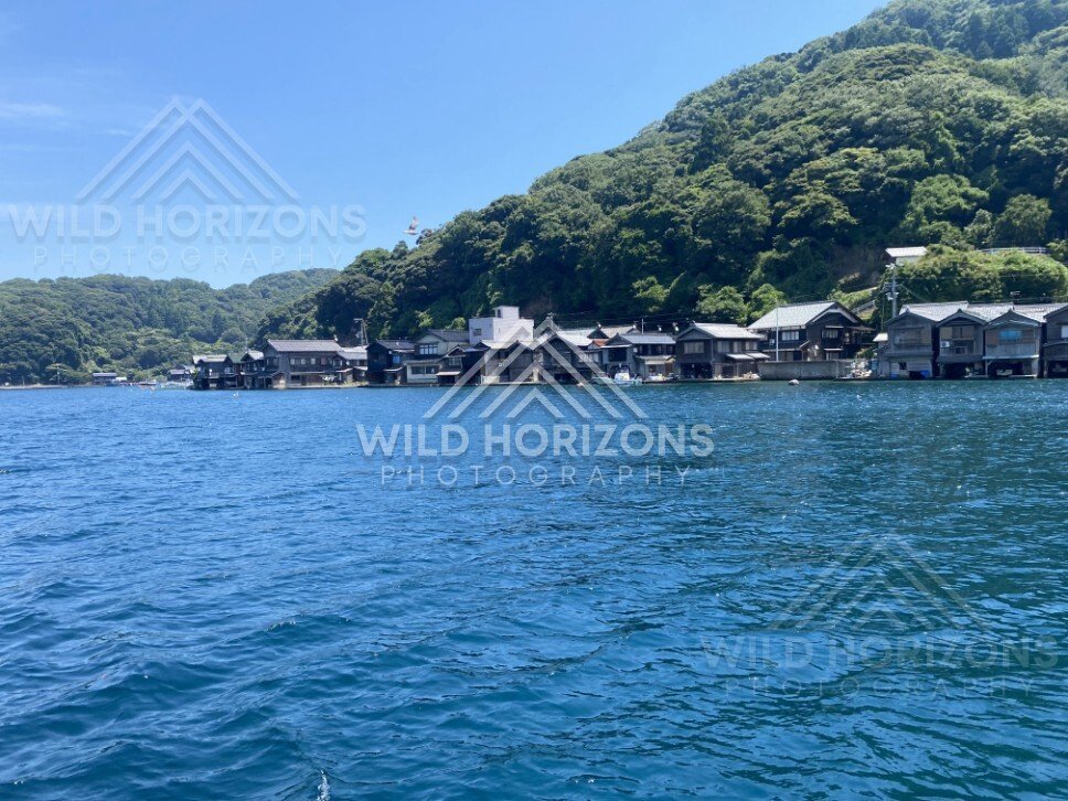 Boathouses and steep green hills rising directly from the bay. Ine, Japan