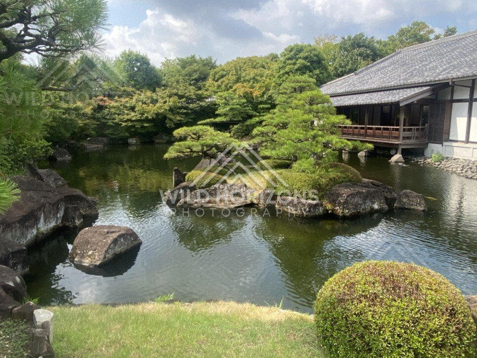 Pine-Covered Island in a Japanese Garden Pond Beside a Wooden Pavilion. Koko-en Garden, Japan.