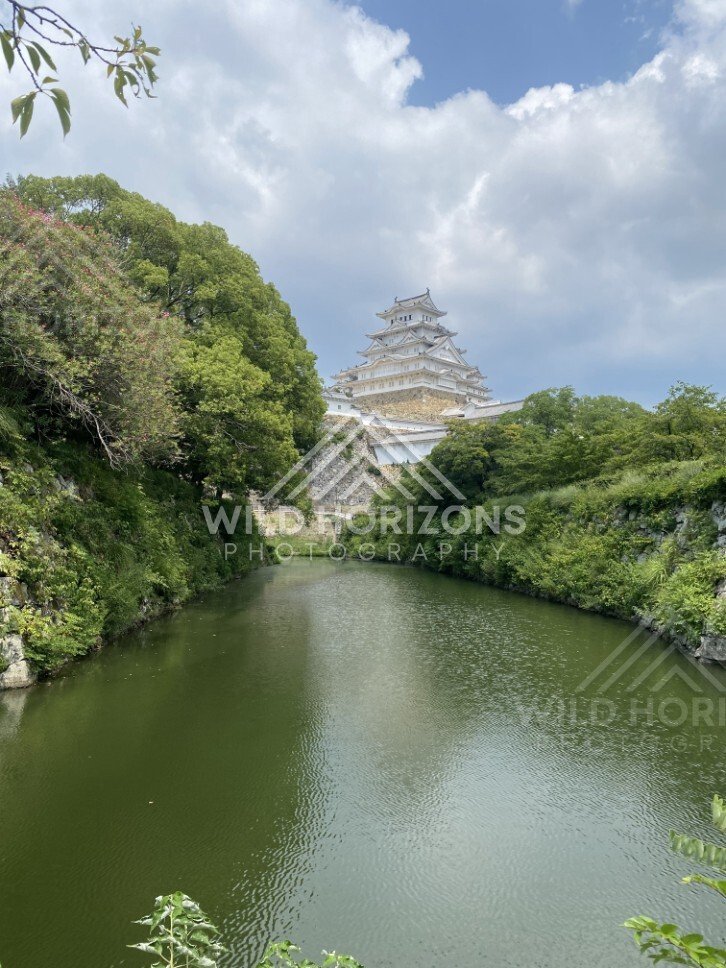 Himeji Castle Rising Above a Green Moat Under Summer Clouds. Himeji, Japan.