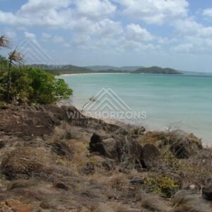 Rocky coastal lookout over turquoise sea and distant headlands. Seisia, Australia.