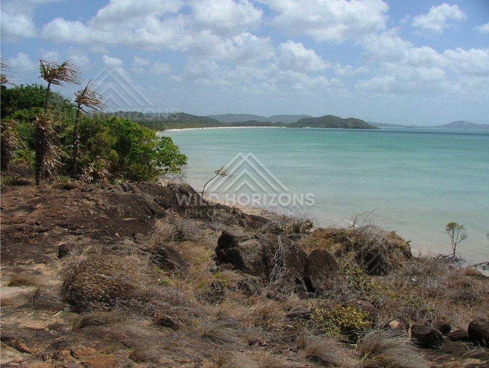 Rocky coastal lookout over turquoise sea and distant headlands. Seisia, Australia.