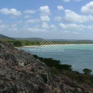 Rocky headland overlooking a broad bay and sandy shoreline. Seisia, Australia.