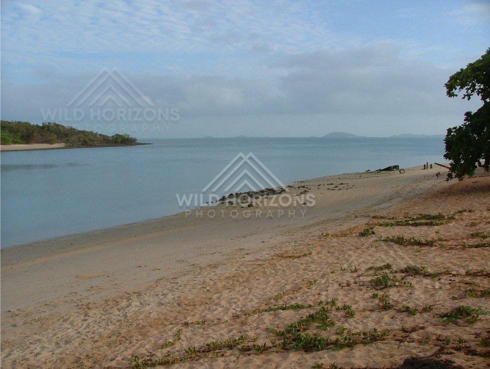 Calm coastal bay viewed across sandy beach at Seisia. Seisia, Australia.