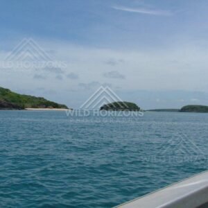 Boat view toward twin islands and sandy shoreline. Seisia, Australia.